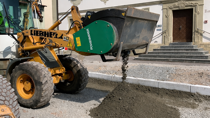 Powermixer Betonmischschaufel am Radlader, bringt Beton an Bordstein aus .