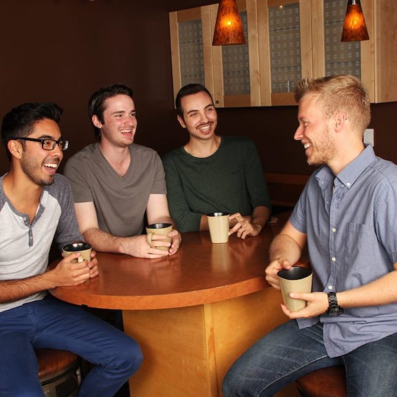 young group of men getting coffee, smiling, laughing