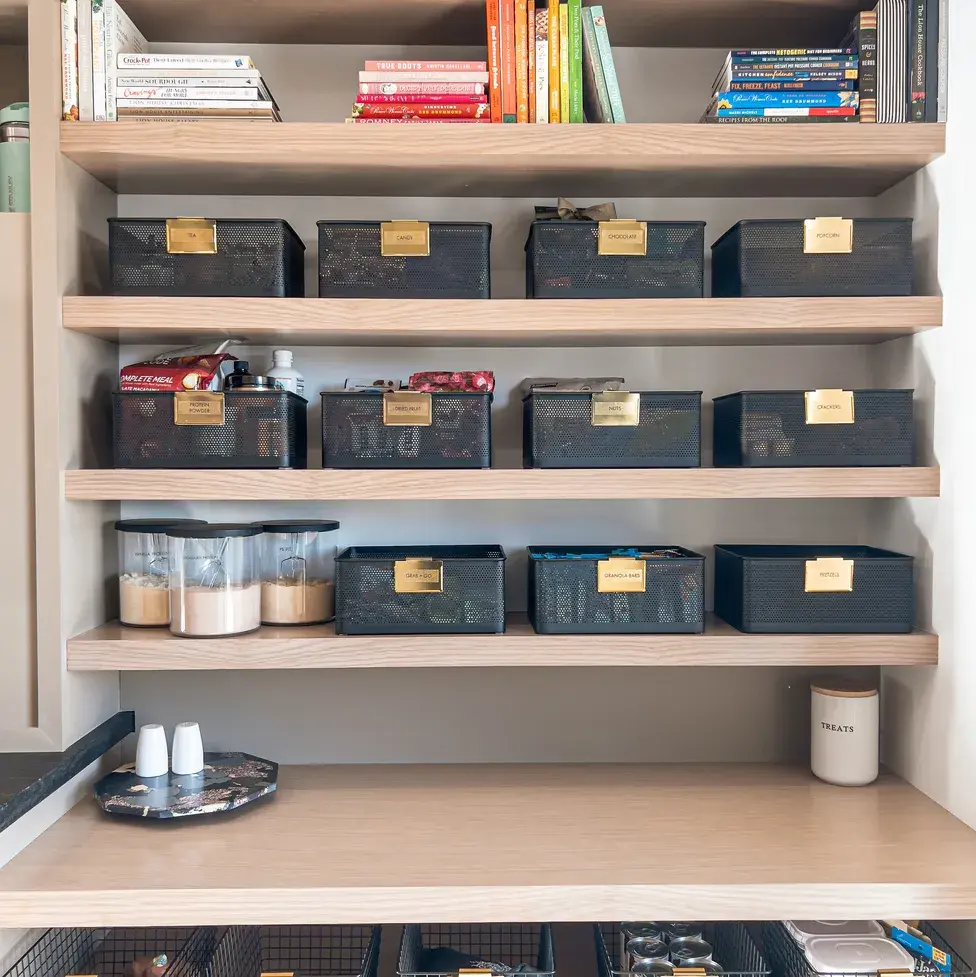 organized pantry with black metal baskets from the neat method